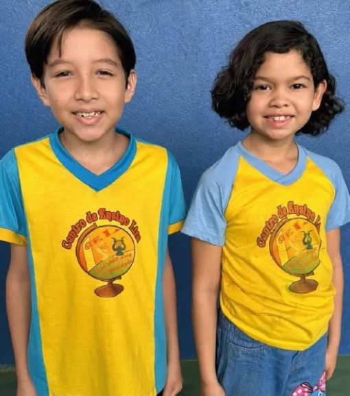 Dois alunos do Centro de Ensino Lira com o uniforme amarelo e azul da escola